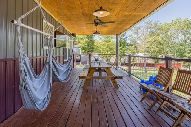 Porch with hammock chairs, picnic table, and tree-lined views